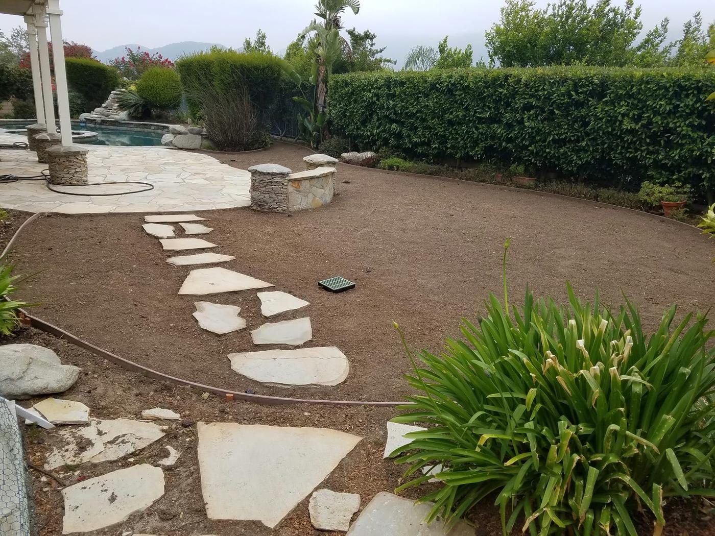 Backyard with bare soil and path work in progress